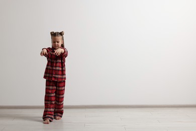 Photo of Girl in pajamas sleepwalking indoors, space for text
