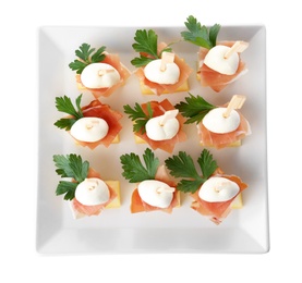 Plate with melon, mozzarella and prosciutto skewers on white background, top view