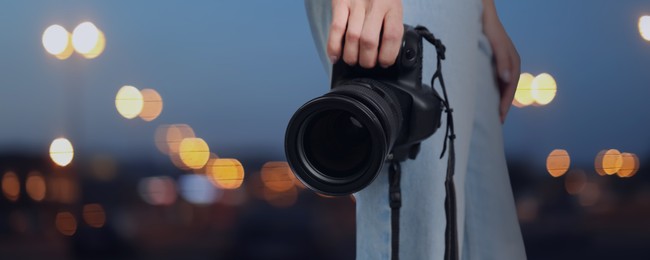 Image of Professional photographer with modern camera and blurred view of beautiful city in evening. Banner design