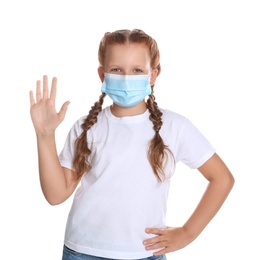 Photo of Little girl in protective mask showing hello gesture on white background. Keeping social distance during coronavirus pandemic