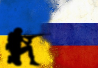 Silhouette of soldier on wall painted in Ukrainian and Russian flags colors, space for text. Military service during war