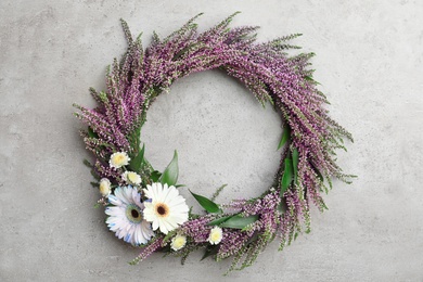 Beautiful autumnal wreath with heather flowers on light grey background, top view. Space for text