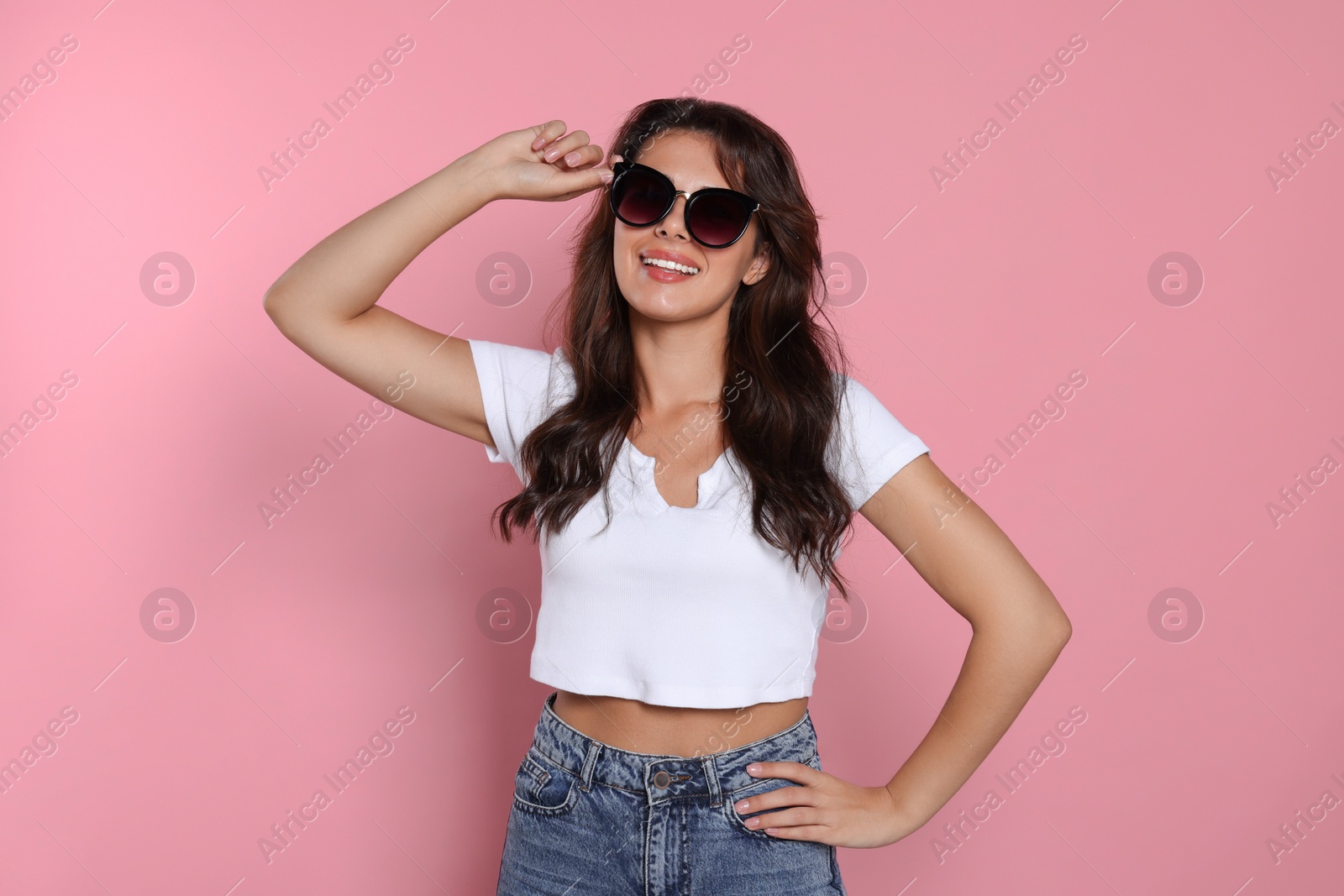 Photo of Happy beautiful woman with stylish sunglasses on pink background