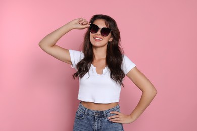 Photo of Happy beautiful woman with stylish sunglasses on pink background