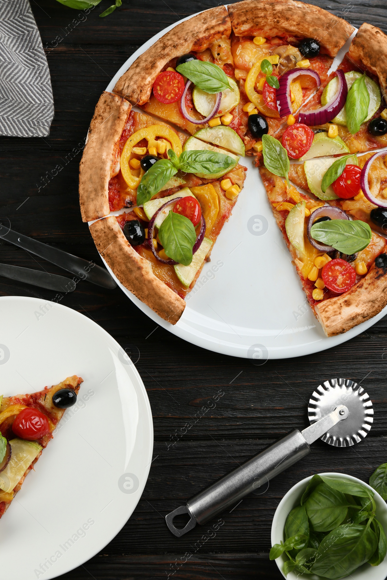 Photo of Flat lay composition with vegetable pizza on black wooden table