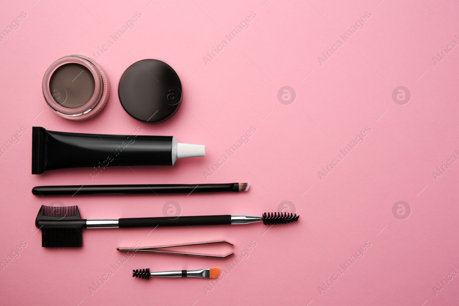 Photo of Flat lay composition with eyebrow henna and tools on pink background. Space for text