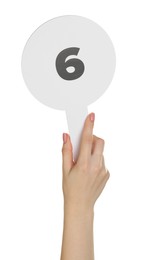 Photo of Woman holding auction paddle with number 6 on white background, closeup
