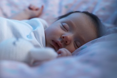 Photo of Cute newborn baby sleeping in crib at night, closeup