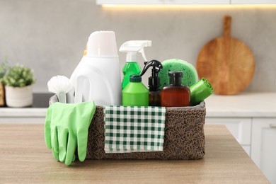 Photo of Different cleaning supplies in basket on table