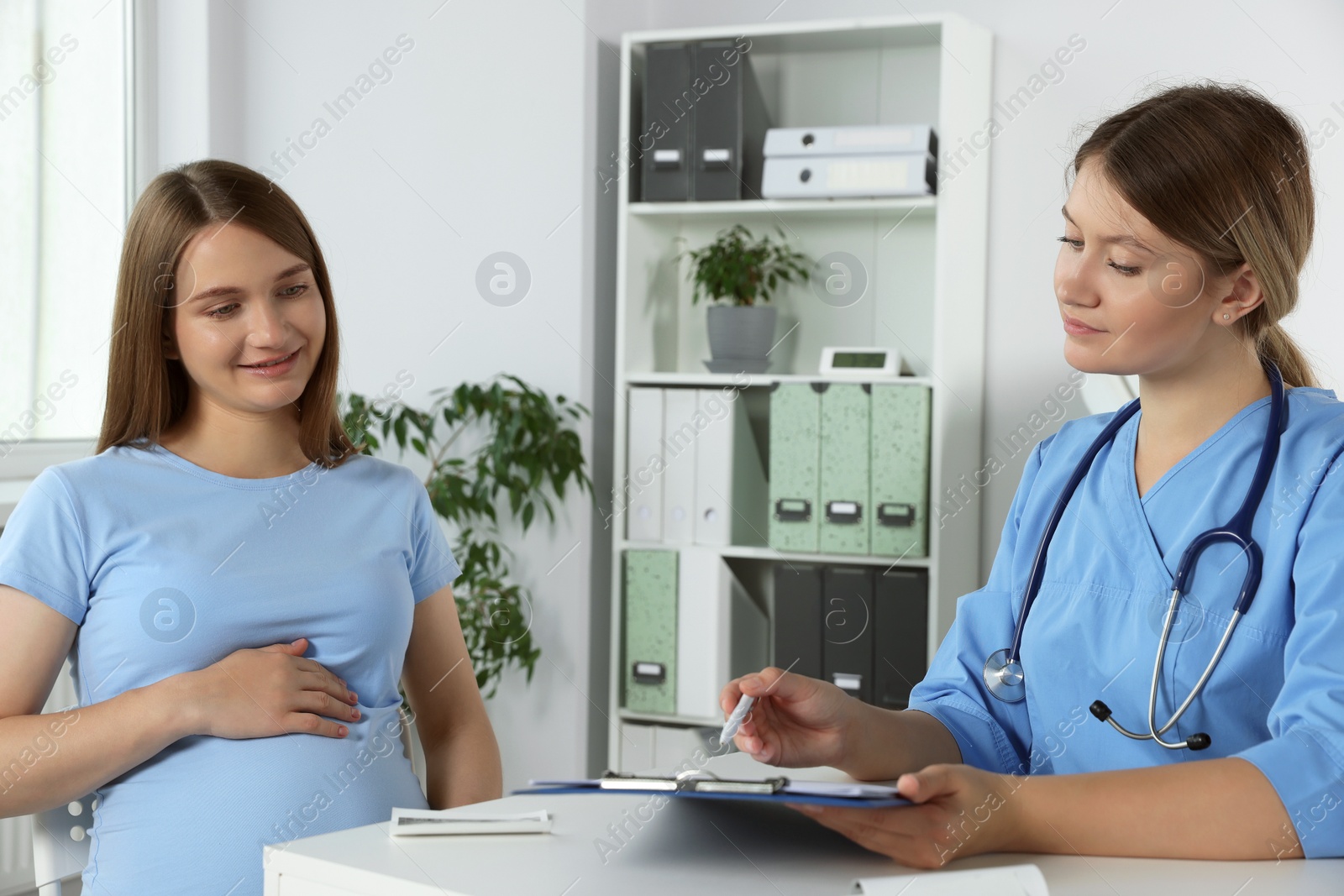 Photo of Happy pregnant woman having doctor appointment in hospital