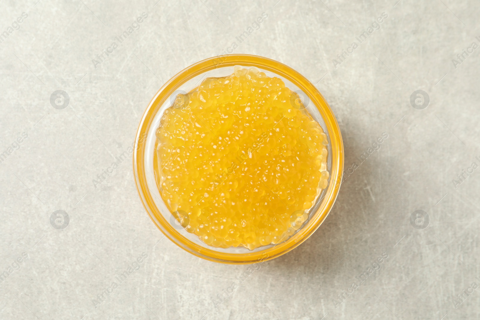 Photo of Fresh pike caviar in bowl on light grey table, top view