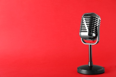 Photo of Retro microphone on color background, space for text