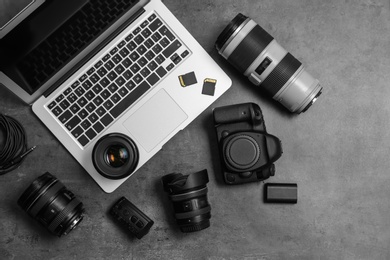 Professional photographer equipment and laptop on gray background, top view