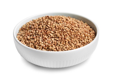 Bowl with uncooked buckwheat on white background