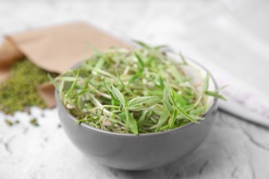 Mung bean sprouts in bowl on white textured table, closeup