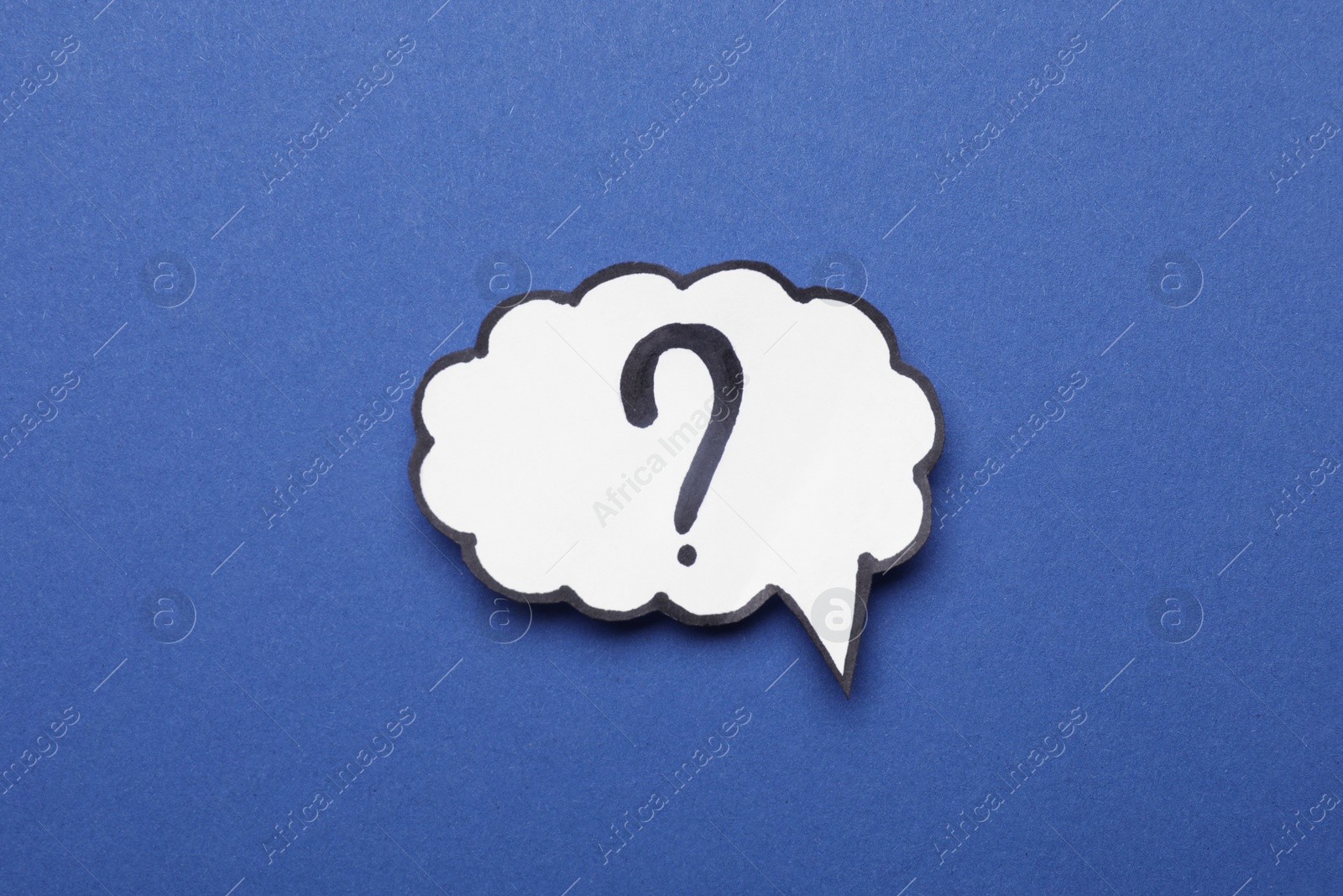 Photo of Paper speech bubble with question mark on blue background, top view