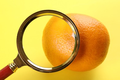 Photo of Cellulite problem. Orange and magnifying glass on yellow background
