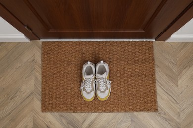 Photo of Stylish shoes on door mat in hall, top view