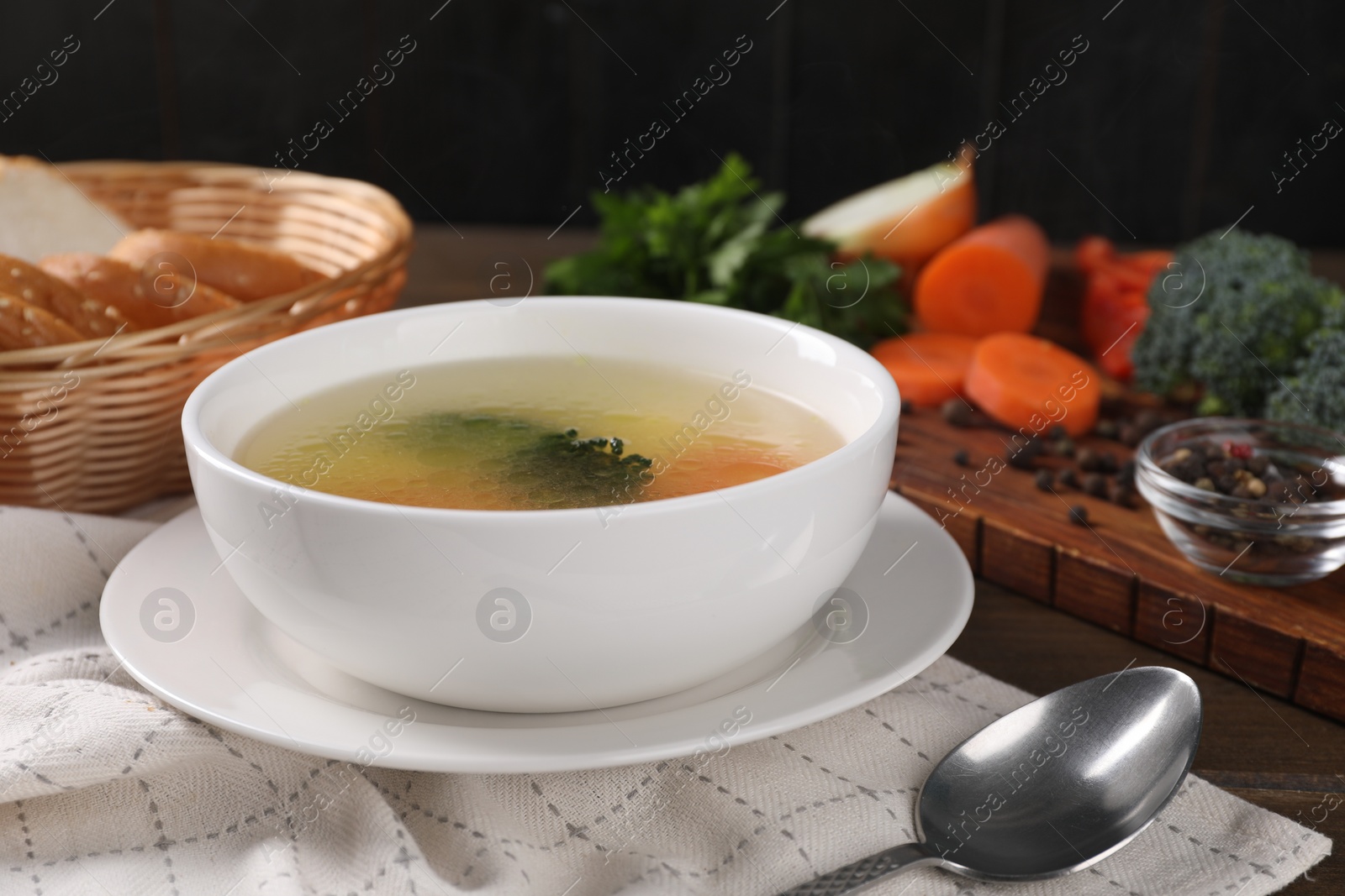 Photo of Tasty soup with vegetables in bowl served on wooden table, closeup