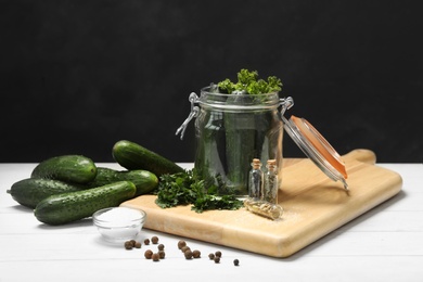 Photo of Pickling jar with fresh ripe cucumbers and spices on white wooden table