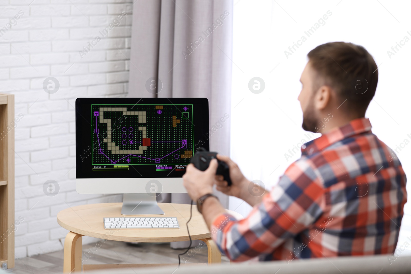 Photo of Young man playing video game at home