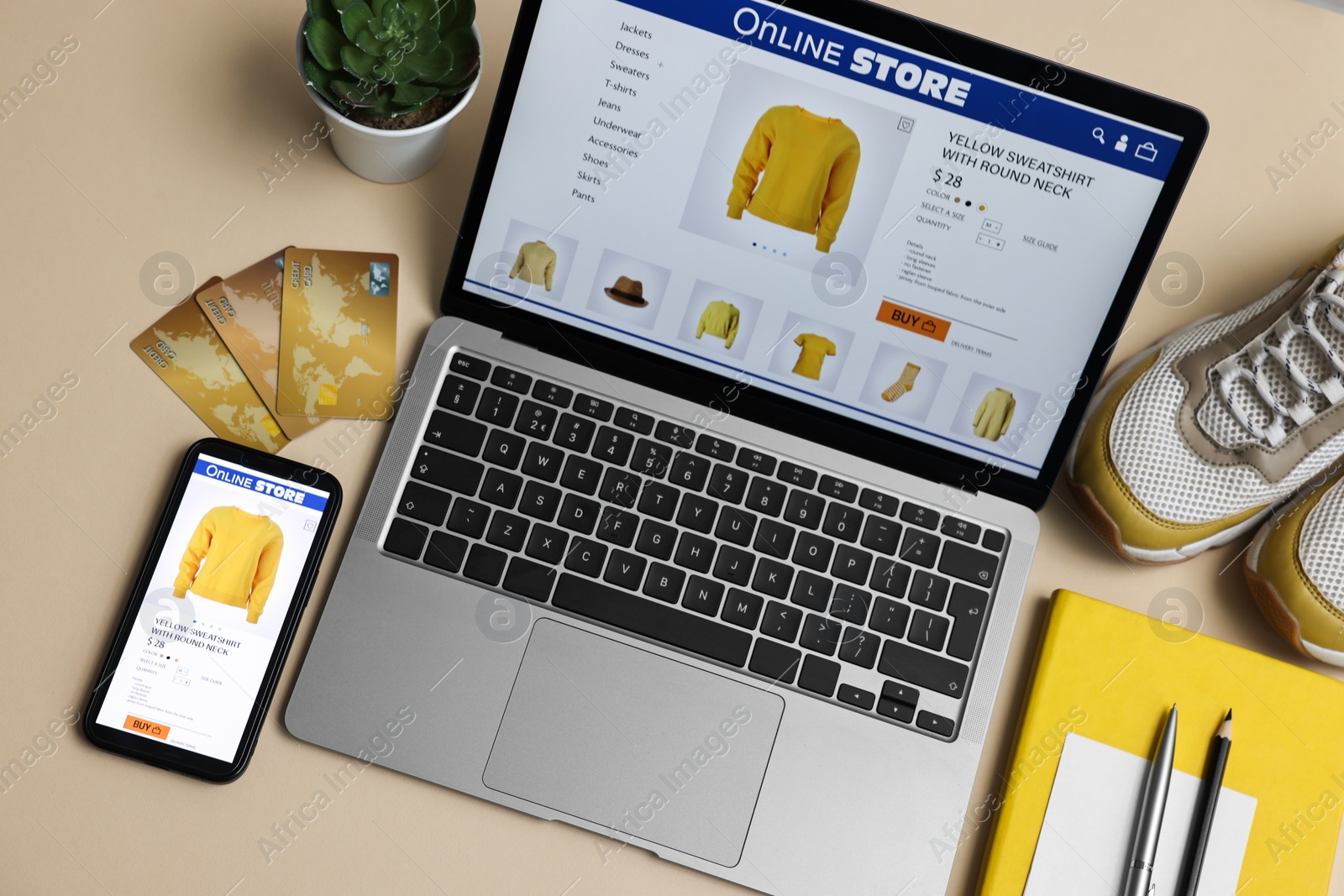 Photo of Online shopping. Composition with laptop on beige background, above view