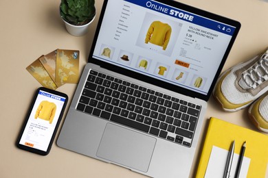 Online shopping. Composition with laptop on beige background, above view