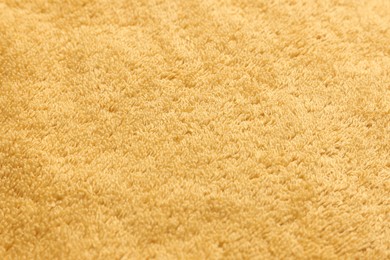 Photo of Dry soft orange towel as background, closeup