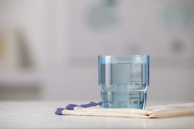 Photo of Glass of pure water on white table indoors, space for text