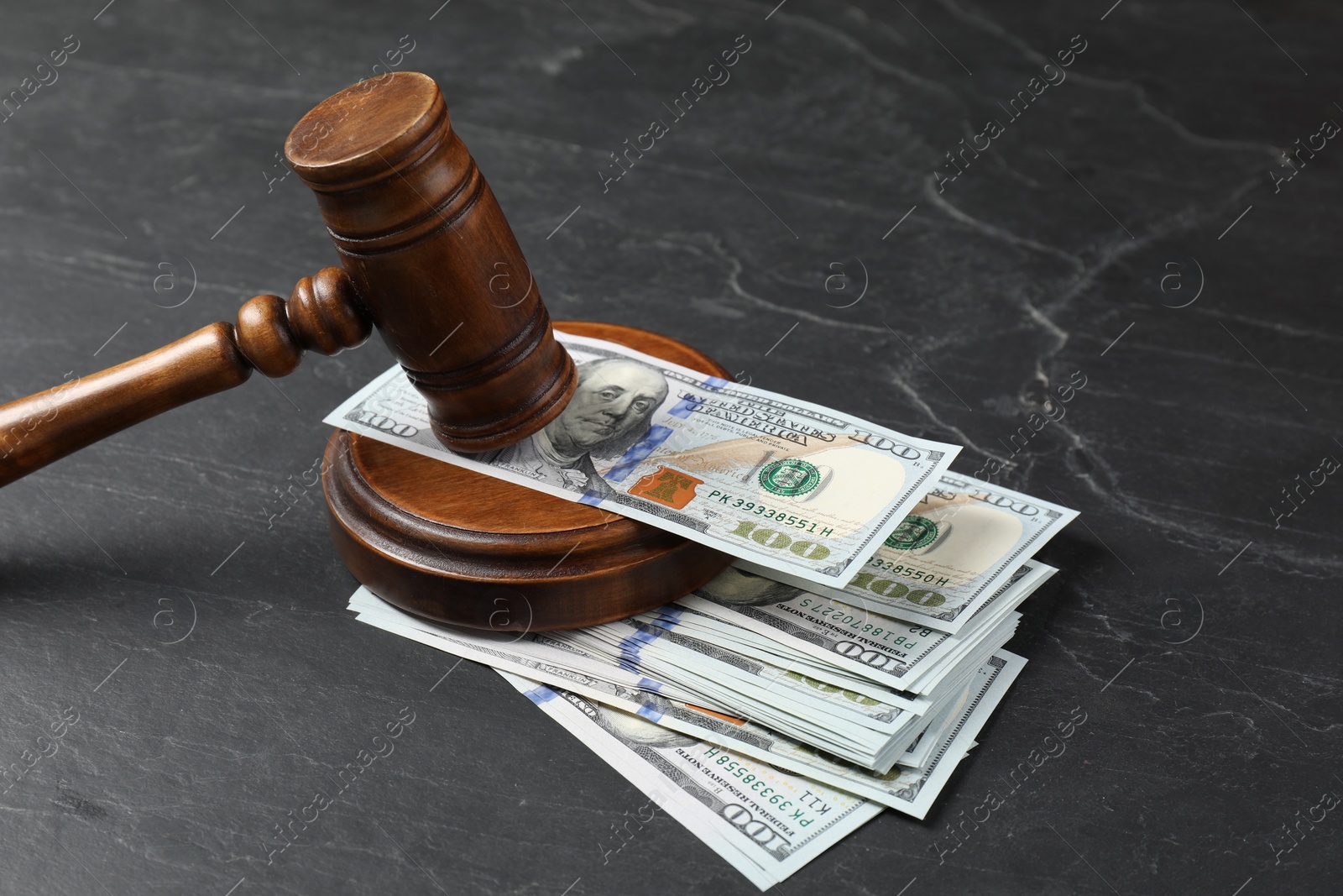 Photo of Judge's gavel and money on dark grey table