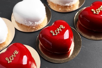 Photo of St. Valentine's Day. Delicious heart shaped cakes on black table, closeup