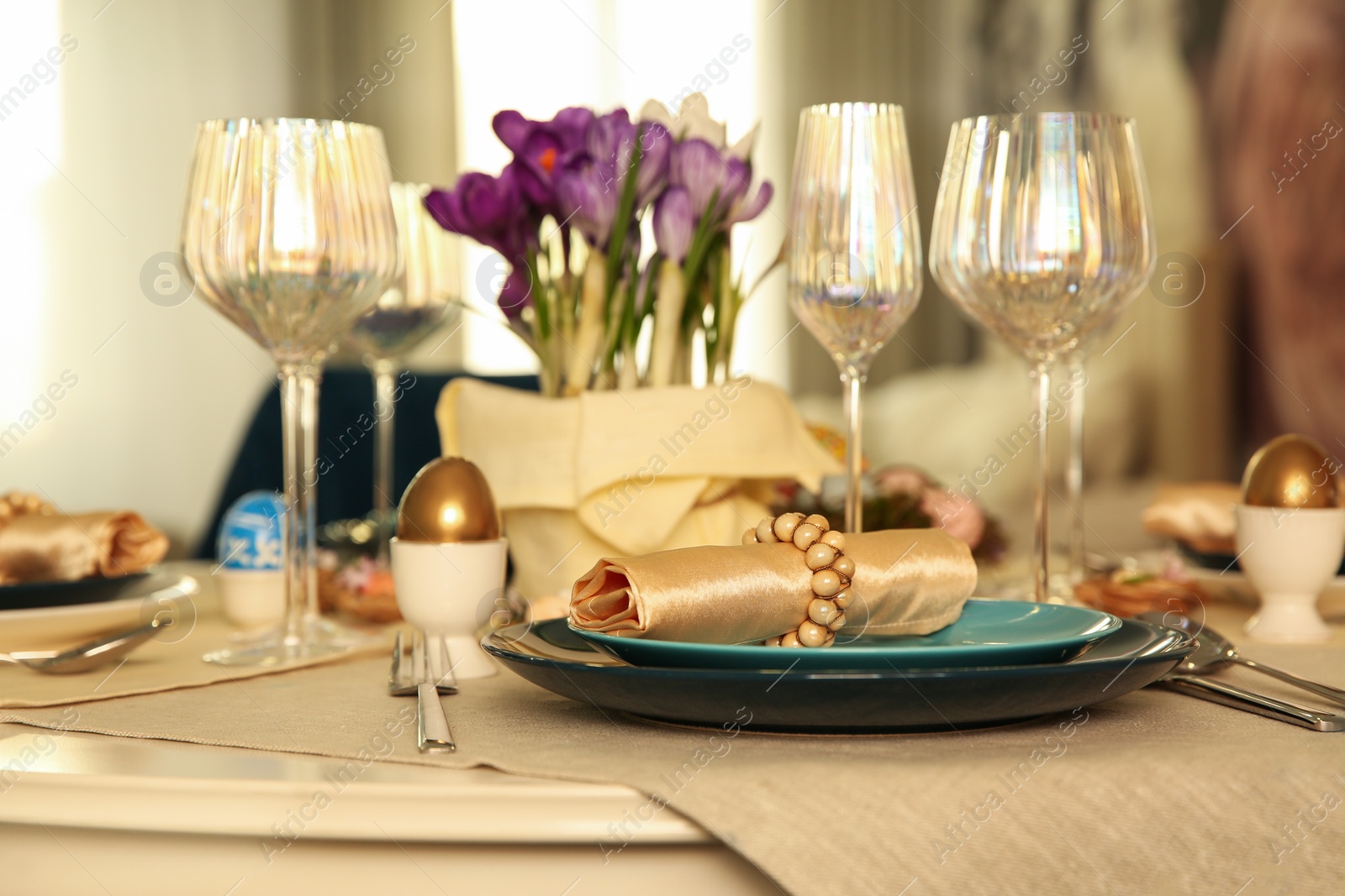 Photo of Festive Easter table setting with decorated eggs in kitchen