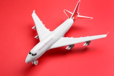 Photo of Toy airplane on red background, closeup. Travel concept