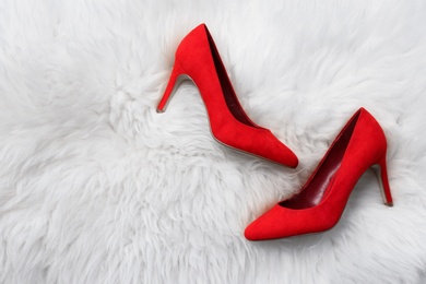 Photo of Elegant female shoes on fluffy carpet