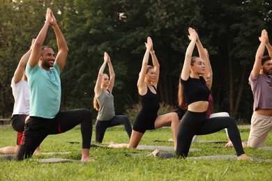 Group of people practicing yoga on mats outdoors