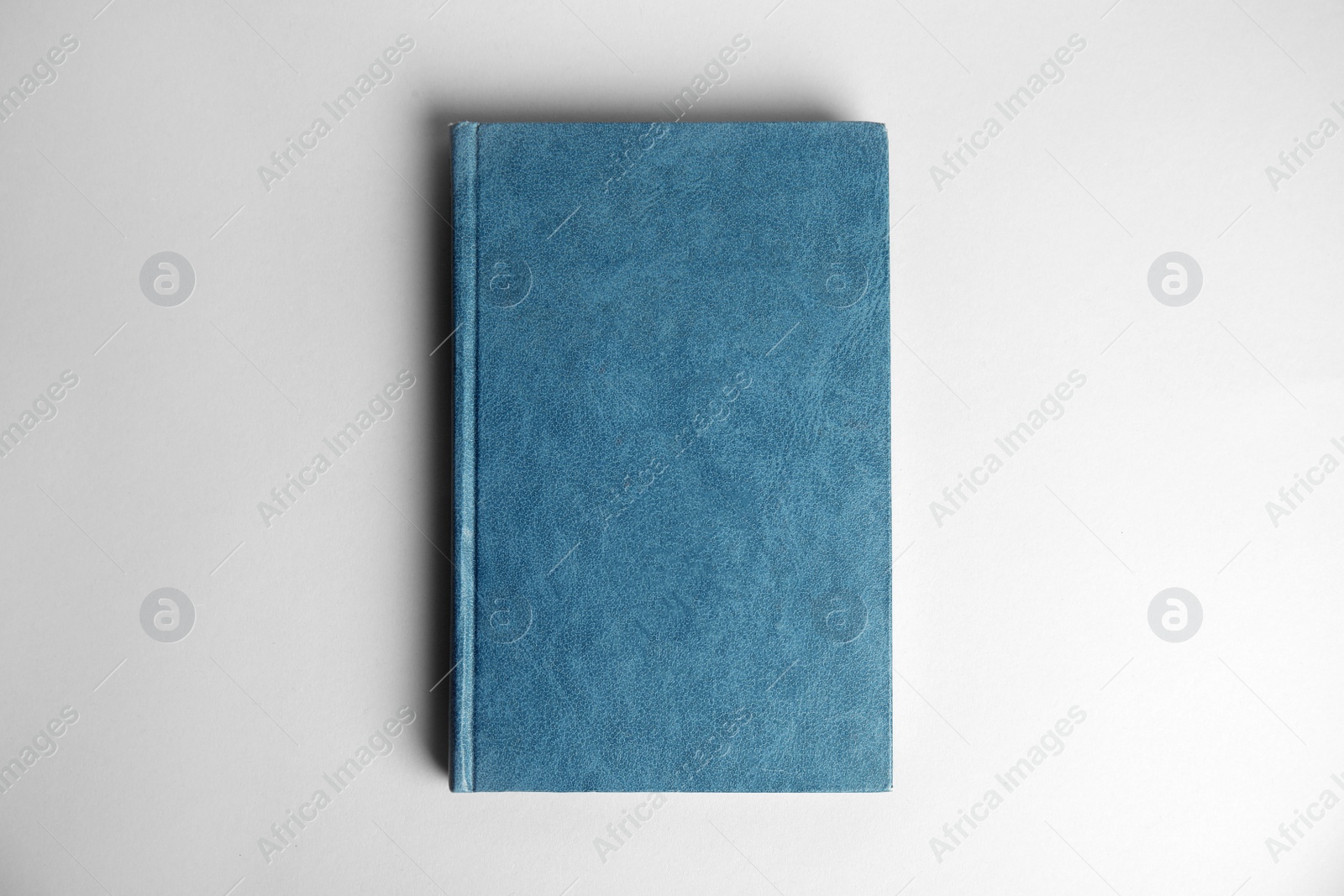 Photo of Hardcover book on light grey background, top view. Space for design