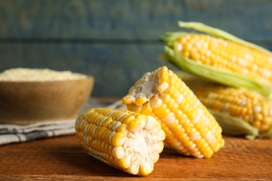 Photo of Tasty sweet corn cobs on wooden table, closeup