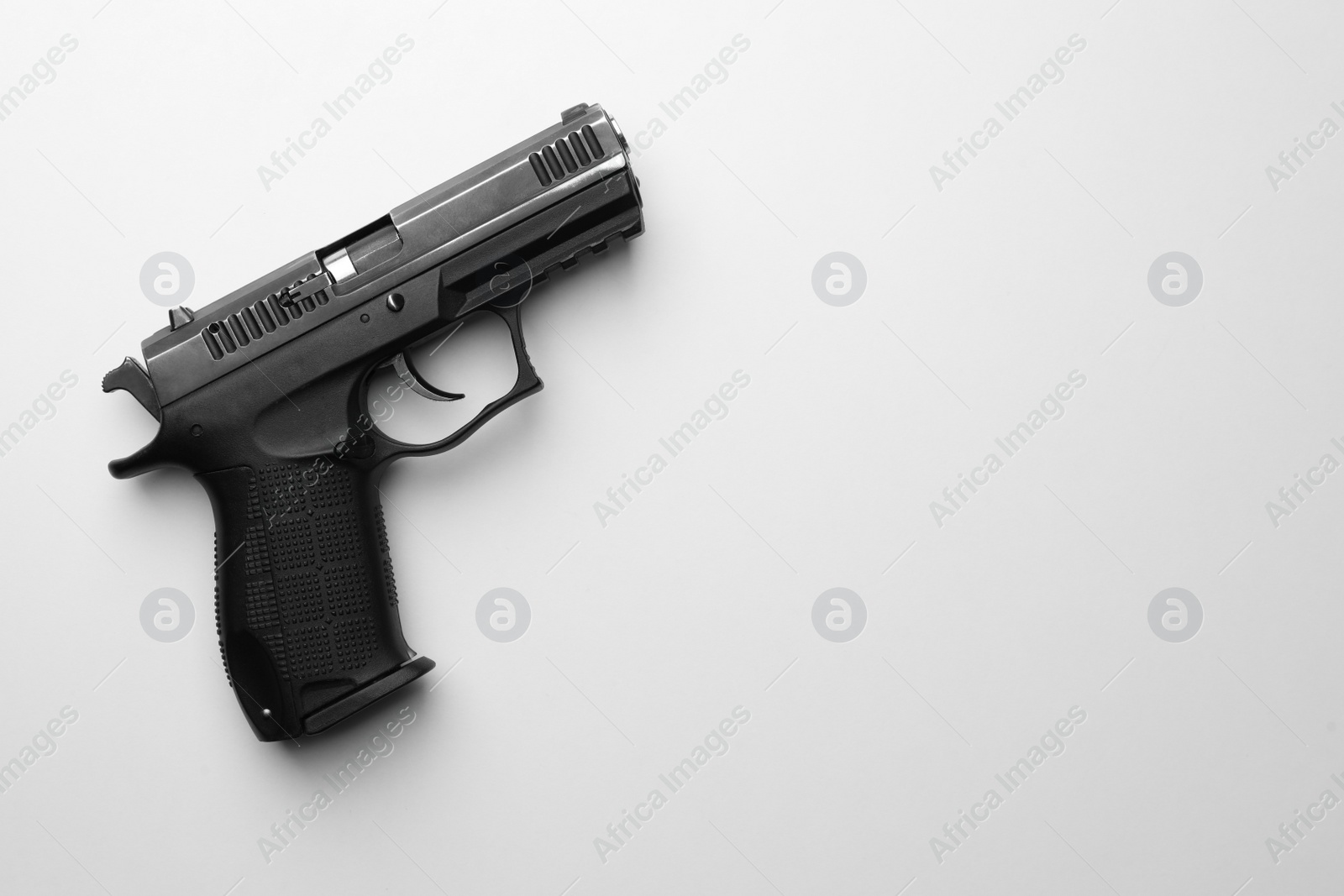 Photo of Semi-automatic pistol on white background, top view. Space for text