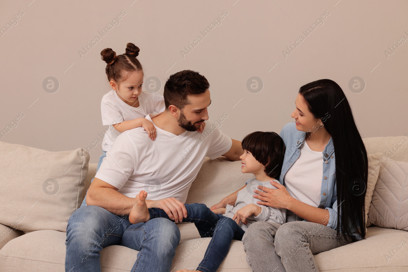 Photo of Happy family resting on sofa in living room