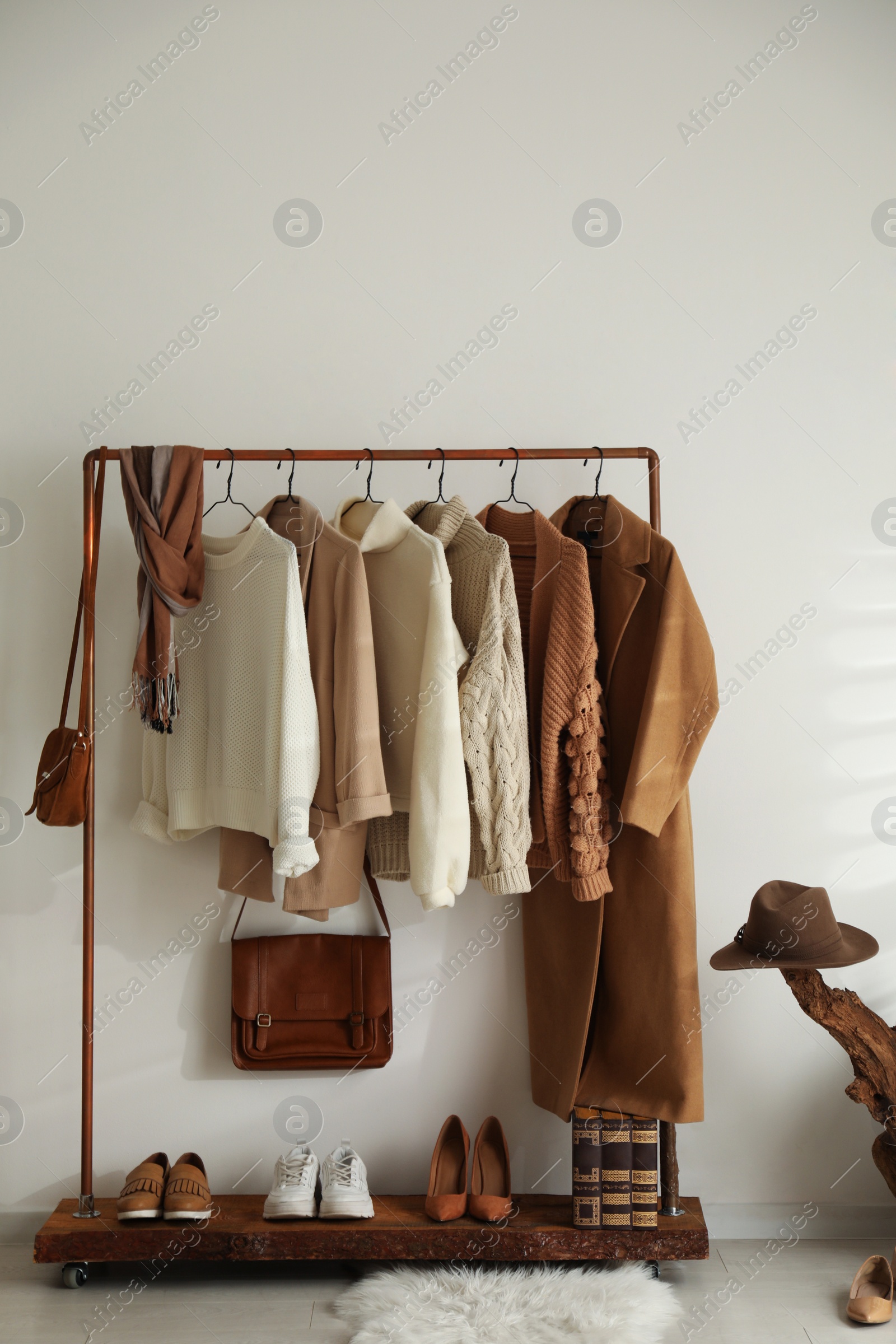 Photo of Modern dressing room interior with rack of stylish shoes and women's clothes