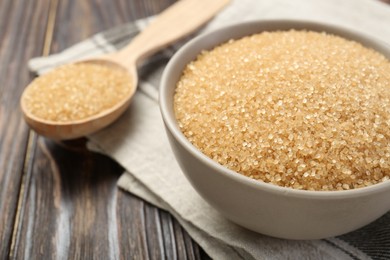 Photo of Brown sugar in bowl on wooden table, closeup