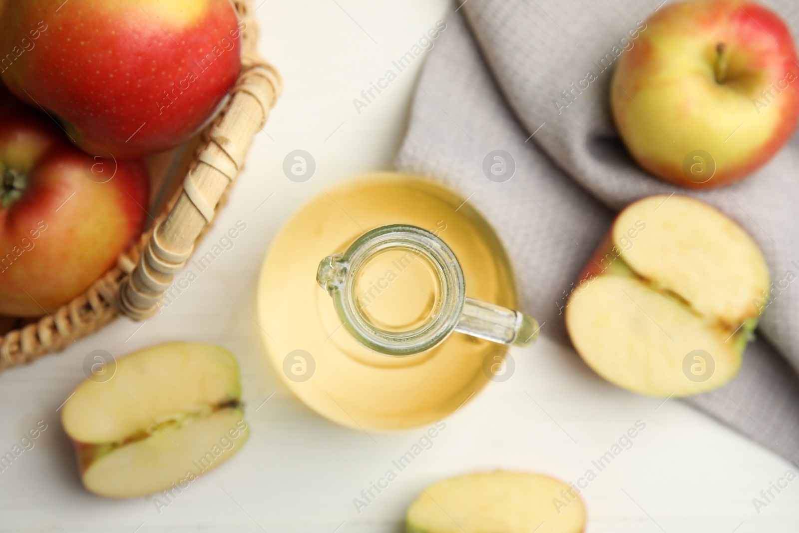 Photo of Natural apple vinegar and fresh fruits on white table, flat lay