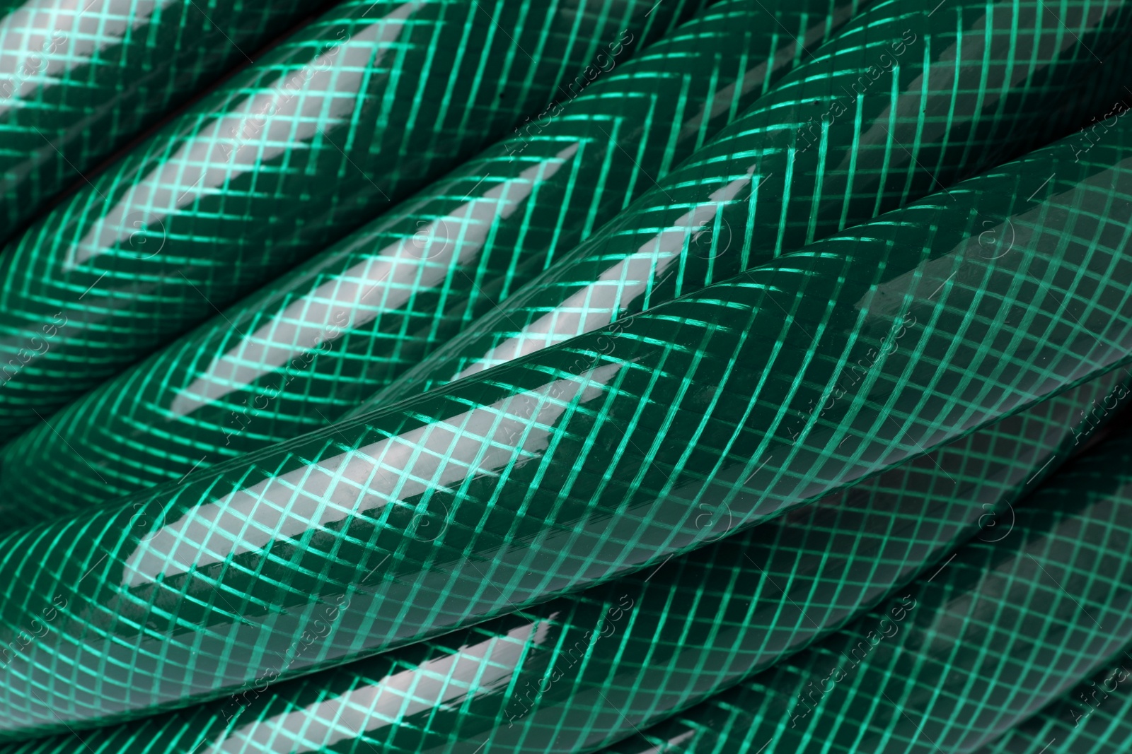 Photo of Green rubber watering hose as background, closeup