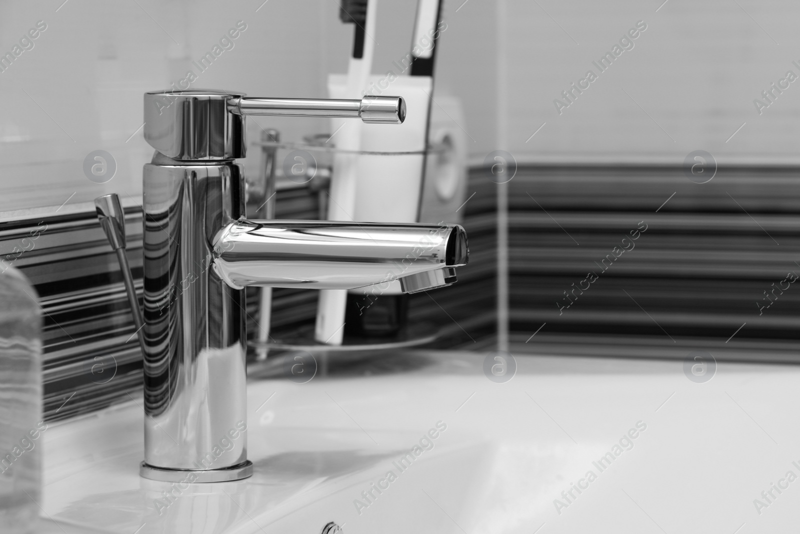 Image of Clean white sink with shiny water tap in bathroom