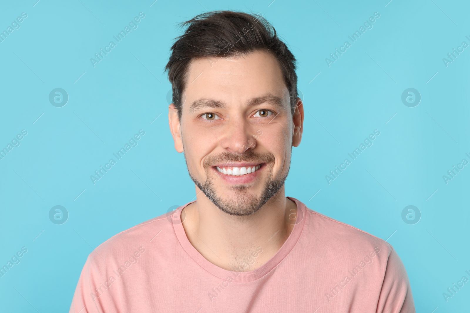 Photo of Smiling man with perfect teeth on color background