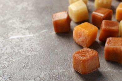 Photo of Different frozen fruit puree cubes on brown marble table, closeup. Space for text