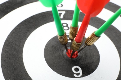 Dart board with color arrows hitting target, closeup