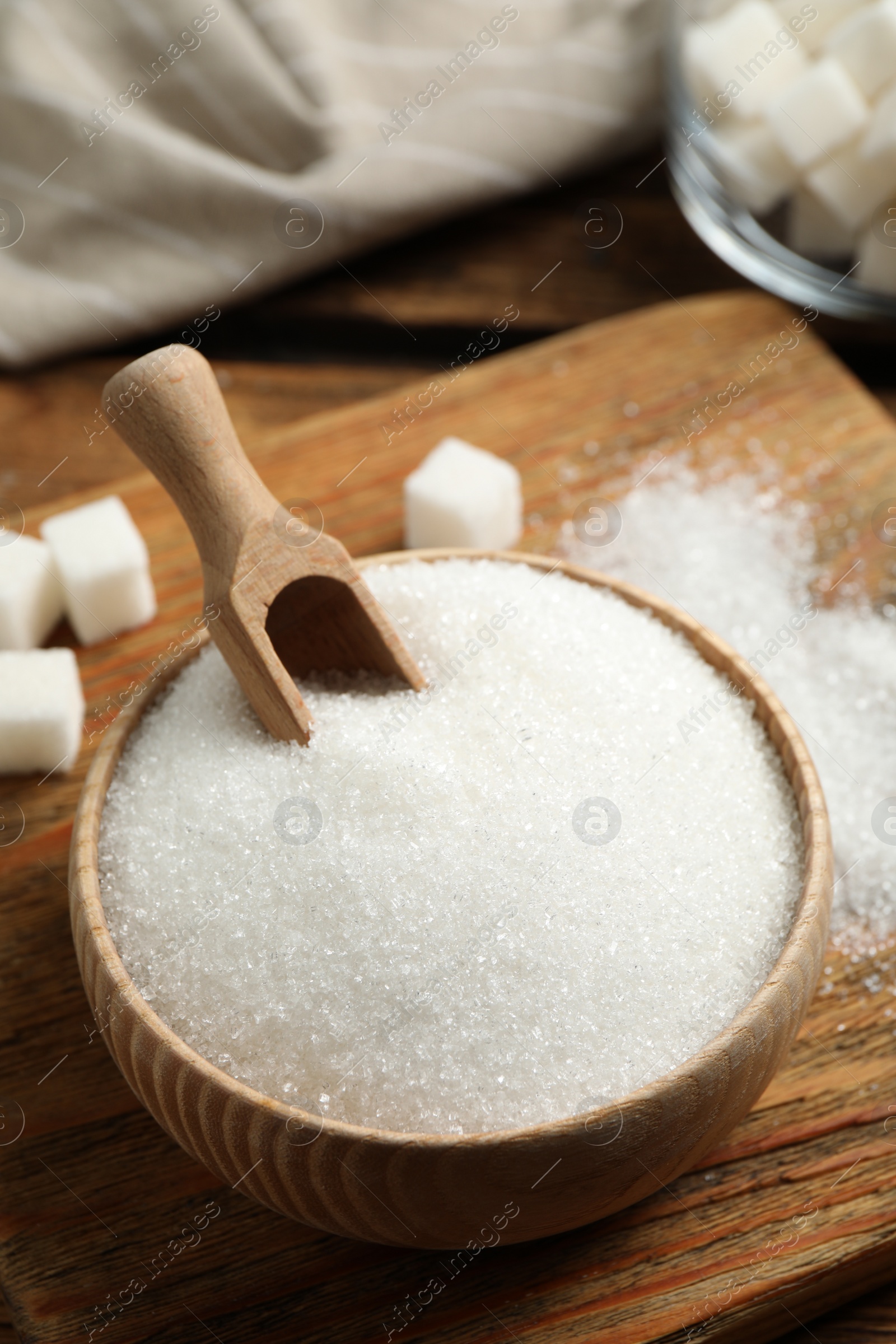 Photo of Granulated sugar in bowl on wooden table