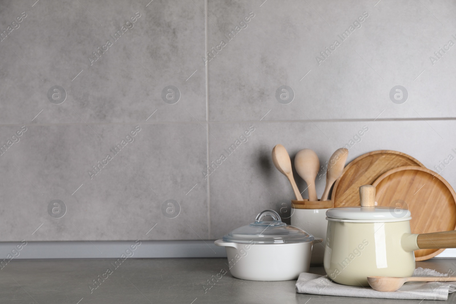 Photo of Set of different cooking utensils on grey countertop in kitchen. Space for text