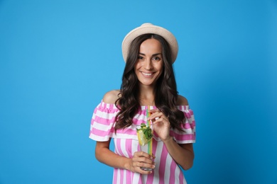 Photo of Young woman with refreshing drink on blue background